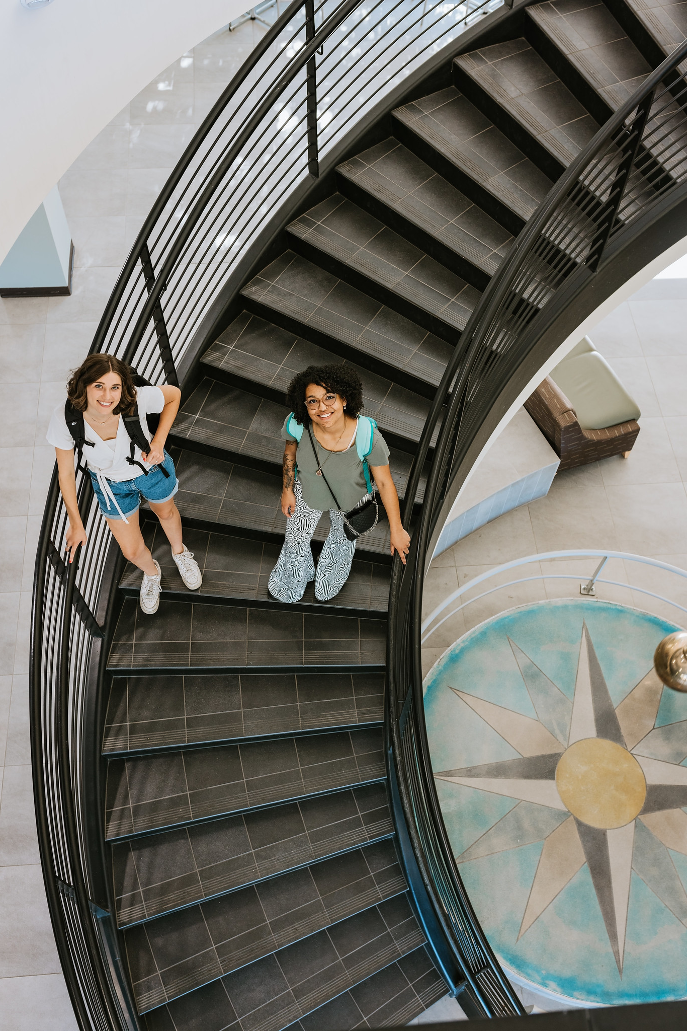 photo of two students smiling on the White Oak Hall staircase