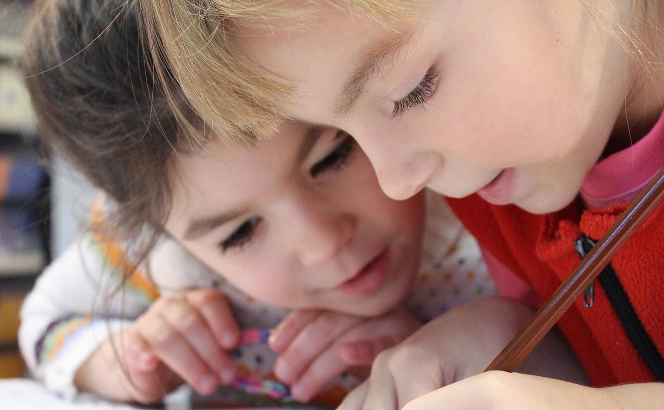 Close up view of two children drawing together