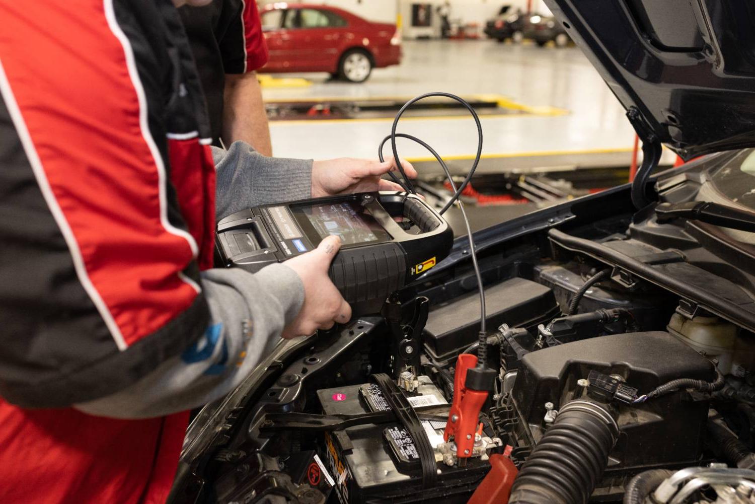 photo of student running diagnostics on a car